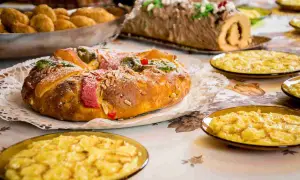 Dolce tipico dell'Epifania: un Roscón de Reyes decorato con frutta candita e mandorle, accompagnato da dolcetti.