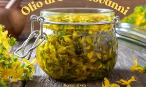 Un barattolo di vetro pieno di fiori di iperico, pronto per la ricetta dell'olio di San Giovanni.