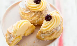 Zeppole di San Giuseppe, dolci soffici con crema pasticcera e ciliegina, perfette per la festa del papà. La ricetta delle zeppole di San Giuseppe è un classico.