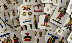 Un mazzo di carte napoletane, con l'asso di bastoni in primo piano, pronto per una partita.