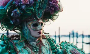 Una maschera veneziana elaborata, con fiori e perle, evoca la storia delle maschere di carnevale.