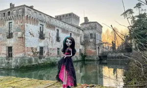 La Dama Bianca leggenda: una bambola gotica posa davanti a un castello antico con un fossato.