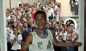 Giovane festante con la maglia "Madonna di Loreto" a Pacentro, tra una folla che filma e applaude.