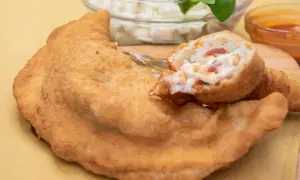 Pizza fritta napoletana: impasto dorato e ripieno cremoso con pomodoro e mozzarella. Ingredienti semplici per un gusto unico.
