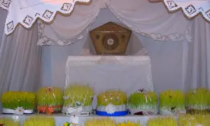 Il giro dei sepolcri: un altare con un ostensorio dorato, circondato da vasi di grano verde decorati con nastri e fiori.