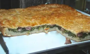 Pizza ripiena salsiccia e friarielli, un classico napoletano dal sapore intenso. La pasta dorata racchiude un cuore verde e saporito.