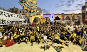 Folla festante in costume, bandiere sventolano, un'atmosfera di festa per la giostra cavalleresca Sulmona.