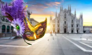 Maschere milanesi decorate con piume e fiori, con il Duomo di Milano sullo sfondo al tramonto.