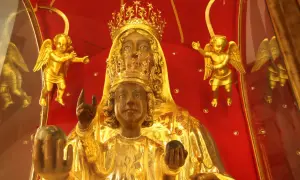 Statua della Madonna Nera, con il Bambino Gesù, circondata da angeli dorati su sfondo rosso.
