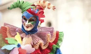 Maschera colorata con cappello a spirale, un costume da giullare che evoca la gioia del carnevale, una festa pagana di travestimenti e allegria.