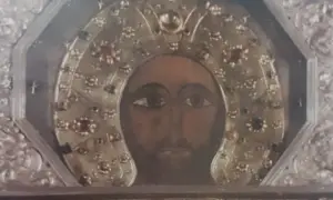 Volto del Cristo Acheropita, icona bizantina con aureola decorata da gemme e ricami dorati, incastonata in una cornice argentata.