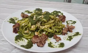 Pasta fresca con crema di friarielli e pezzetti di salsiccia croccante. Un piatto gustoso e colorato.