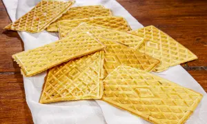 Un mucchio di ferratelle dolci, croccanti e dorate, pronte per essere gustate su un tovagliolo bianco.