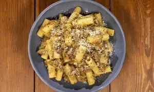 Piatto di pasta con sugo ricco e formaggio grattugiato, una deliziosa finta genovese napoletana.