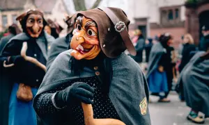 Maschere spaventose e costumi tradizionali in una sfilata, forse quando è Epifania.