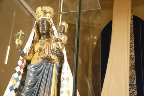 Statua di una Madonna Nera con Bambino, riccamente vestita, che evoca il madonna nera significato esoterico.