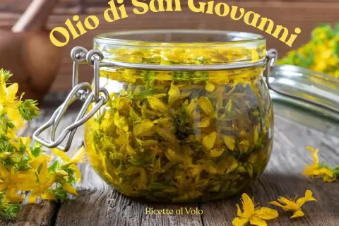 Un barattolo di vetro pieno di fiori di iperico, pronto per la ricetta dell'olio di San Giovanni.