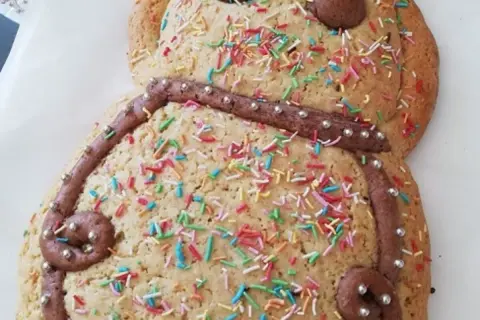 Dolce a forma di pupazzo, decorato con glassa al cioccolato, zuccherini colorati e perline argentate. Una deliziosa ricetta pupa abruzzese pronta da gustare.