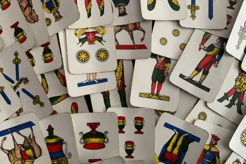 Un mazzo di carte napoletane, con l'asso di bastoni in primo piano, pronto per una partita.