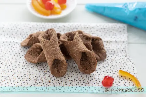 Scorza cannoli siciliani ricetta originale: croccanti involucri pronti per essere farciti, con canditi e ciliegina a lato.