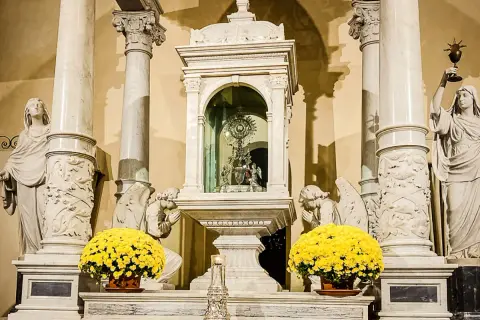 Altare con ostensorio scintillante, angeli adoranti e fiori gialli, evocando un miracolo eucaristico.