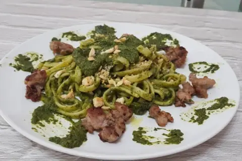 Pasta fresca con crema di friarielli e pezzetti di salsiccia croccante. Un piatto gustoso e colorato.
