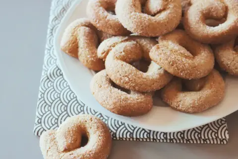 Ciambelle all'anice abruzzesi, dolcetti dorati cosparsi di zucchero, invitano a un assaggio di tradizione.
