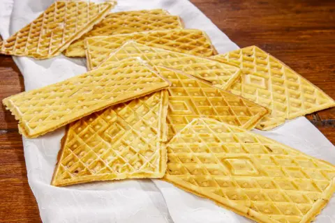 Un mucchio di ferratelle dolci, croccanti e dorate, pronte per essere gustate su un tovagliolo bianco.