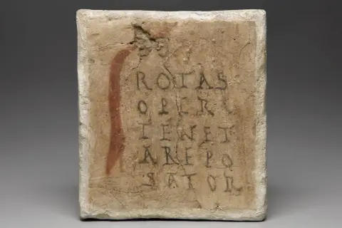 Tavoletta con il quadrato magico del Sator, un antico enigma testuale la cui traduzione è ancora dibattuta.