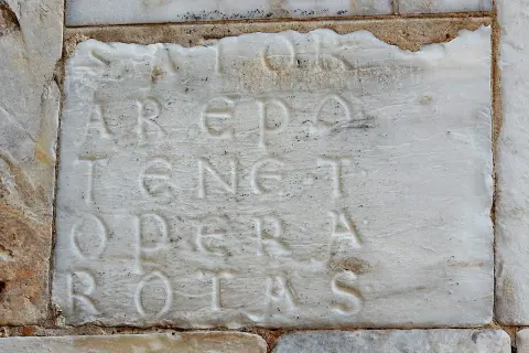 Incisione su marmo con il palindromo Sator Arepo Tenet Opera Rotas, un antico enigma che sfida il tempo.