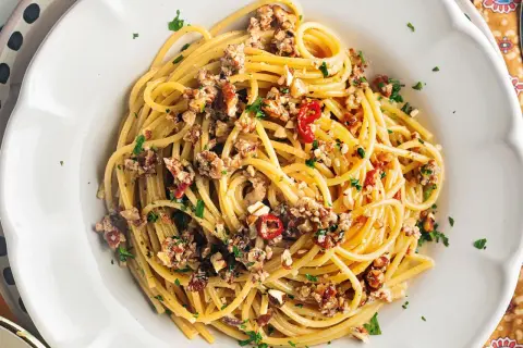 Spaghetti con le noci, un sapore autentico della ricetta napoletana, conditi con noci tritate, peperoncino e prezzemolo fresco.
