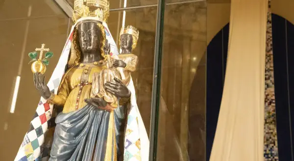 Statua di una Madonna Nera con Bambino, riccamente vestita, che evoca il madonna nera significato esoterico.