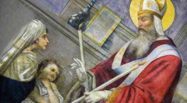 La storia di San Biagio: il santo vescovo benedice un bambino con una spina in gola, mentre una donna osserva.