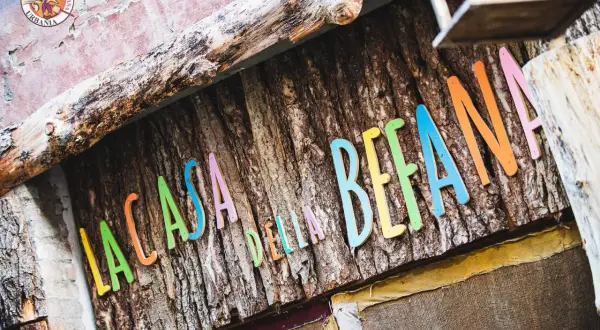 La casa della Befana, con lettere colorate su corteccia. Un luogo magico dove la fantasia prende vita.