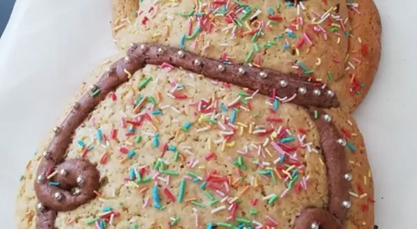 Dolce a forma di pupazzo, decorato con glassa al cioccolato, zuccherini colorati e perline argentate. Una deliziosa ricetta pupa abruzzese pronta da gustare.