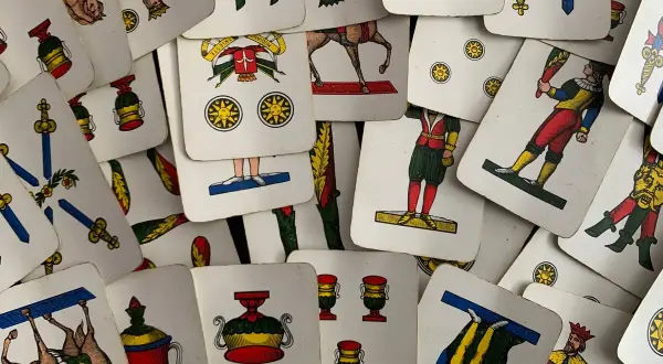 Un mazzo di carte napoletane, con l'asso di bastoni in primo piano, pronto per una partita.