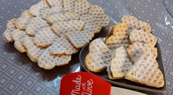 Cuore di cialde morbide spolverate di zucchero a velo, pronte per essere gustate.