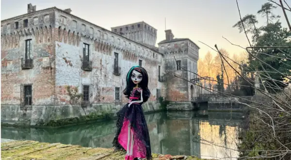 La Dama Bianca leggenda: una bambola gotica posa davanti a un castello antico con un fossato.