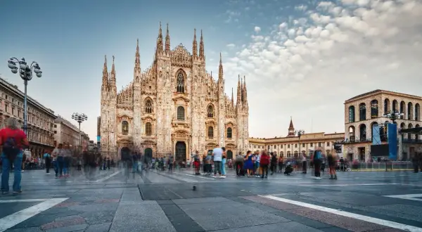 Piazza del Duomo a Milano, con la cattedrale imponente e gente che passeggia. Un luogo dove si respira la storia e i proverbi milanesi.