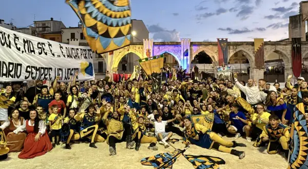 Folla festante in costume, bandiere sventolano, un'atmosfera di festa per la giostra cavalleresca Sulmona.