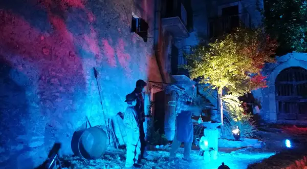 Scenografia suggestiva per la festa delle streghe in Abruzzo. Figure misteriose e luci colorate creano un'atmosfera magica.