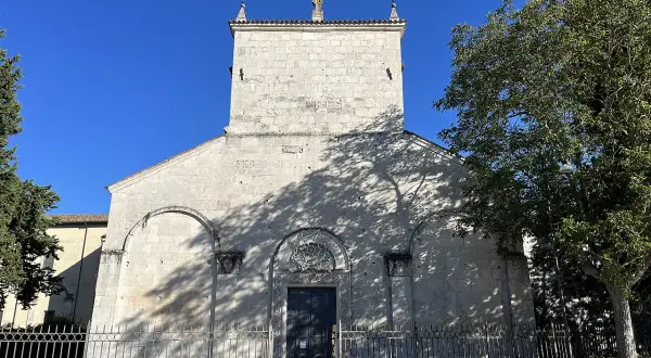 Chiesa di San Pelino a Corfinio, un'antica struttura in pietra sotto un cielo azzurro.