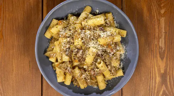 Piatto di pasta con sugo ricco e formaggio grattugiato, una deliziosa finta genovese napoletana.