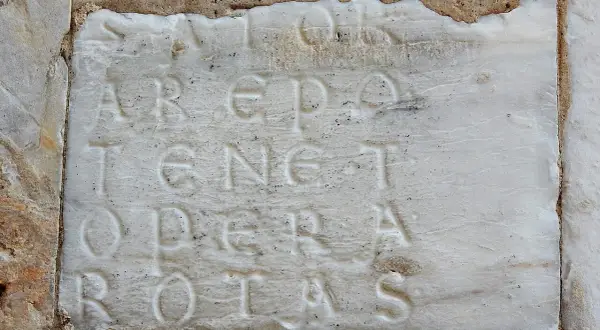 Incisione su marmo con il palindromo Sator Arepo Tenet Opera Rotas, un antico enigma che sfida il tempo.