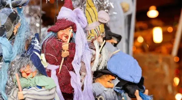 Befane napoletane con scope e cappelli colorati, pronte per la festa della Befana.