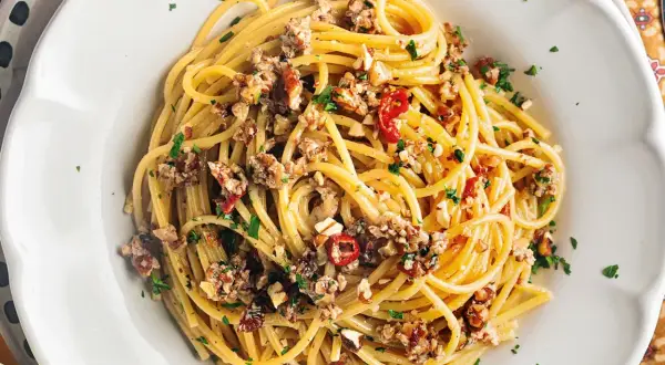 Spaghetti con le noci, un sapore autentico della ricetta napoletana, conditi con noci tritate, peperoncino e prezzemolo fresco.