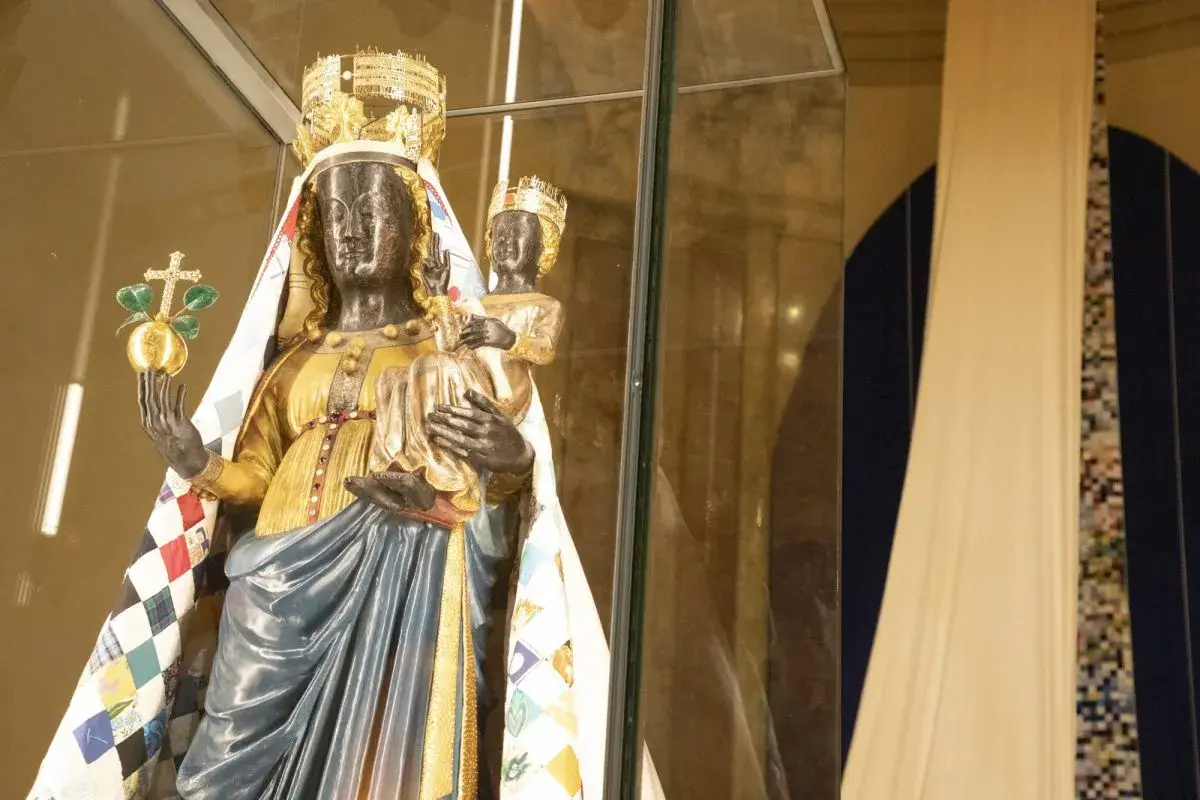Statua di una Madonna Nera con Bambino, riccamente vestita, che evoca il madonna nera significato esoterico.
