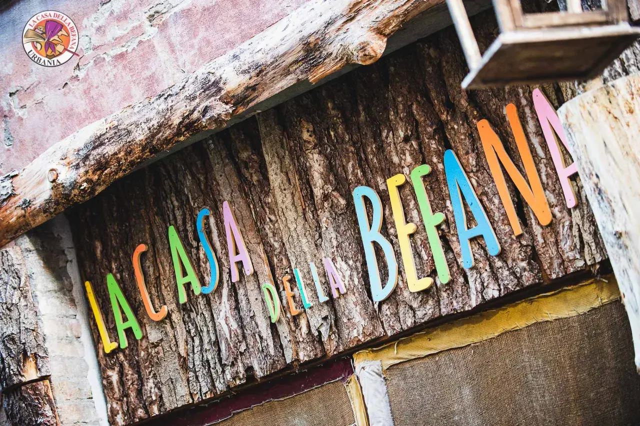 La casa della Befana, con lettere colorate su corteccia. Un luogo magico dove la fantasia prende vita.