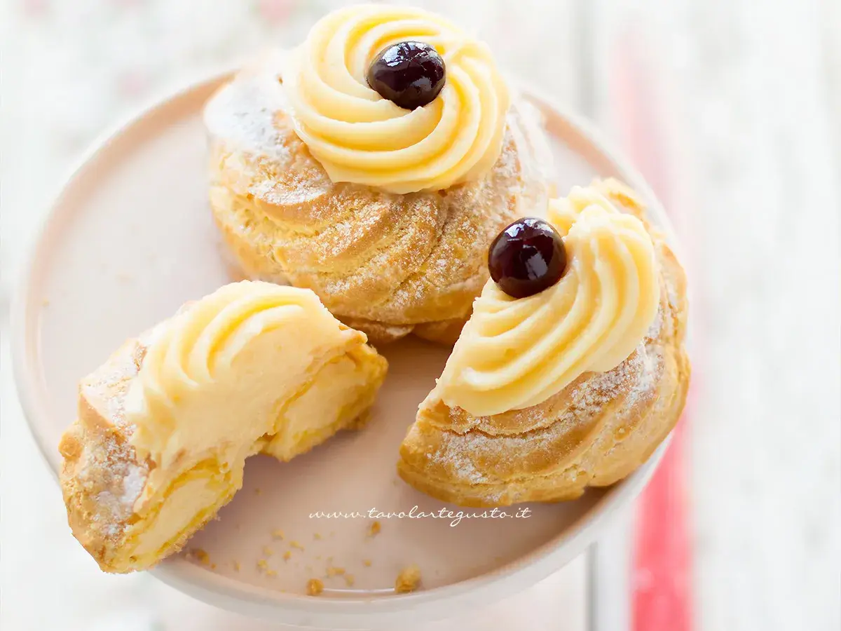 Zeppole di San Giuseppe, dolci soffici con crema pasticcera e ciliegina, perfette per la festa del papà. La ricetta delle zeppole di San Giuseppe è un classico.