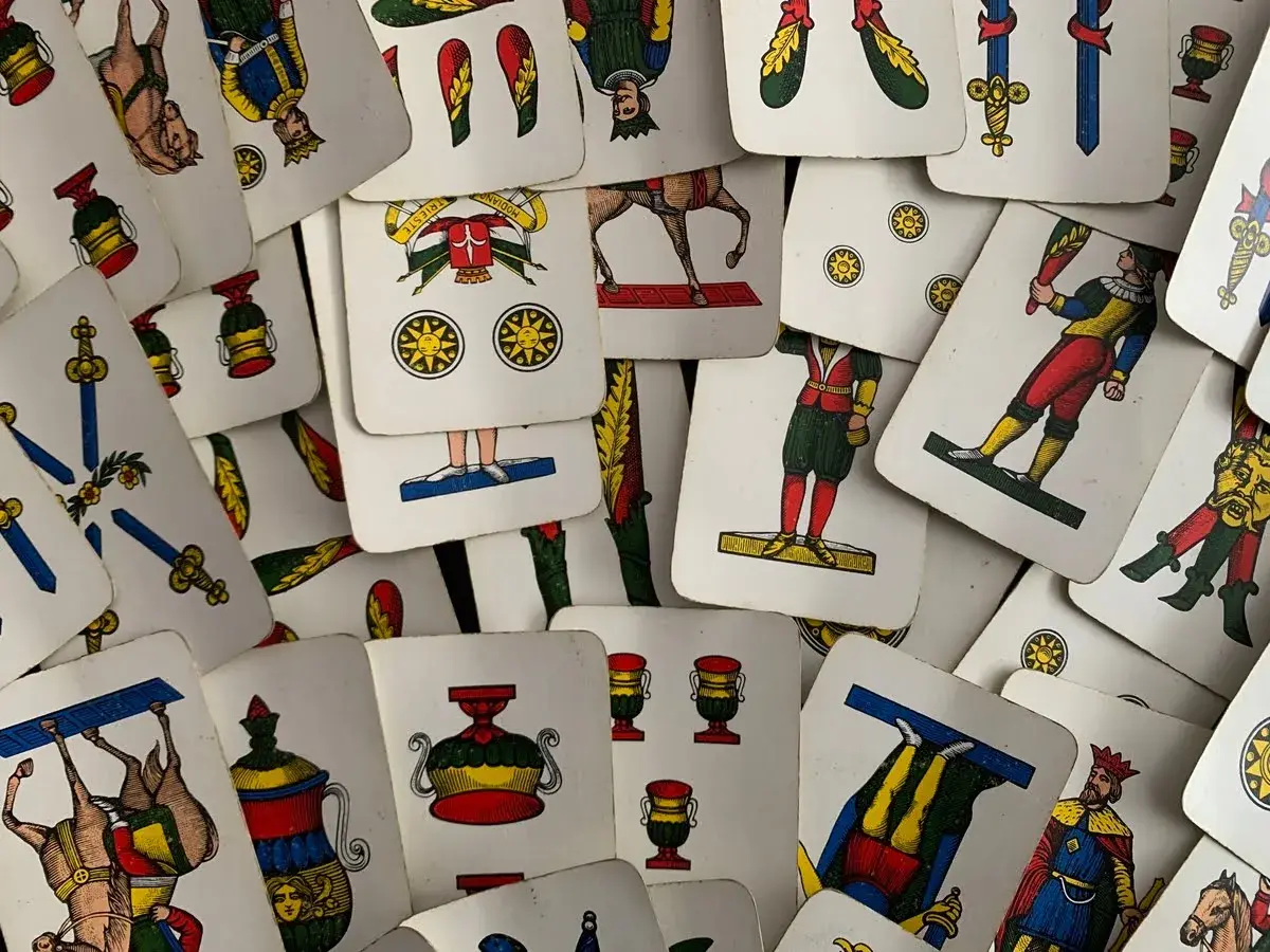 Un mazzo di carte napoletane, con l'asso di bastoni in primo piano, pronto per una partita.